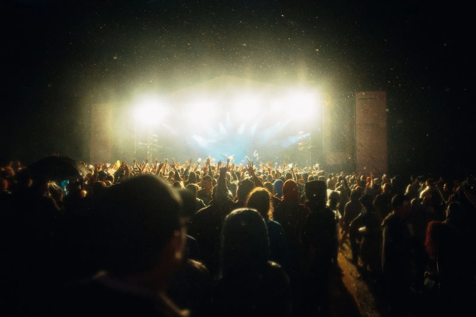 Publikum vor einer hell beleuchteten Festivalbühne bei Nacht