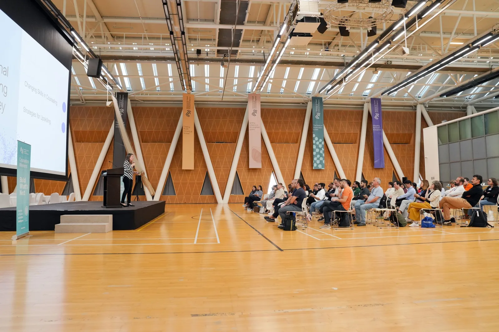 Große Tagung: Publikum hört einem Redner am Podium zu